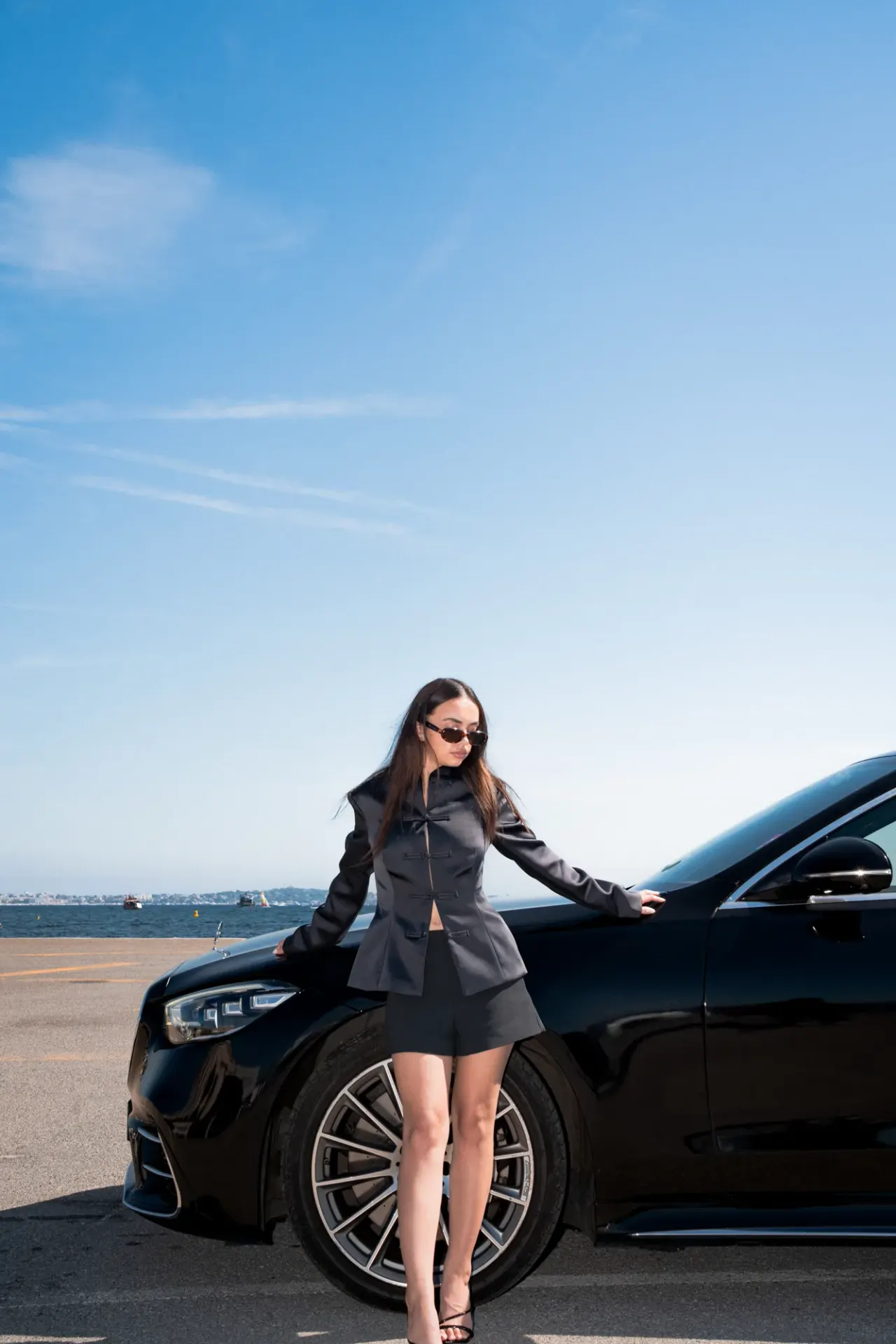 Chauffeur privé à Cannes — cliente au bord de la Mercedes Classe S, face à la mer