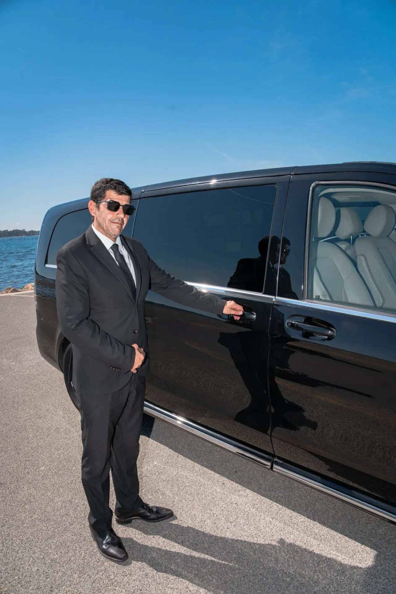 Van avec chauffeur à Nice — le chauffeur en costume à la porte du Classe V